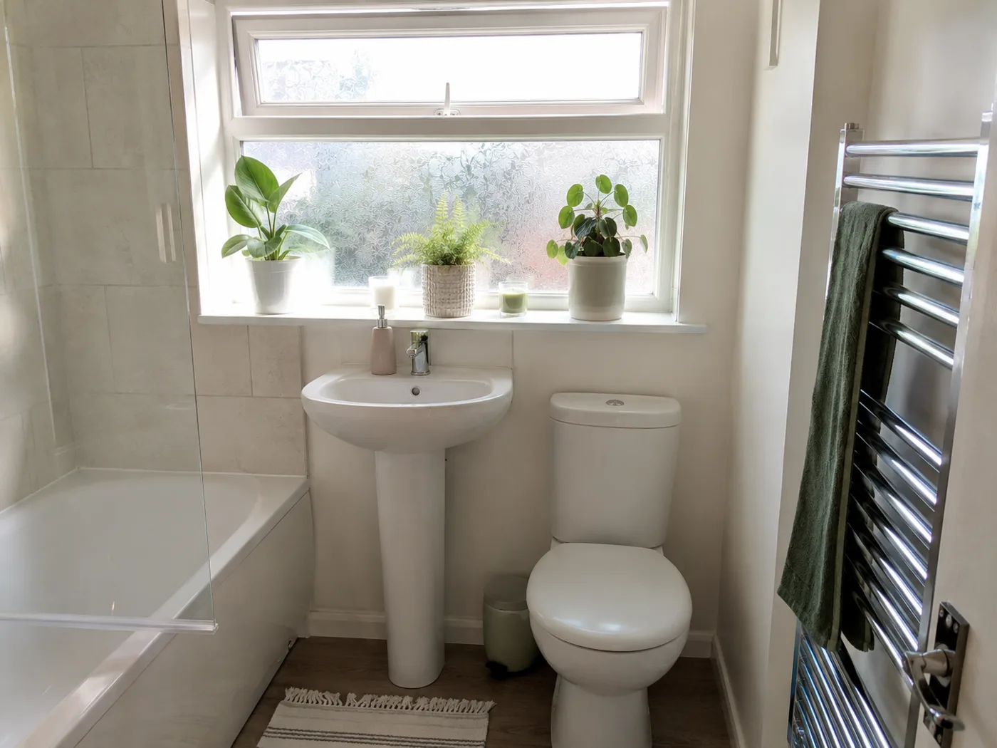 Freestanding chrome towel rail beside bathtub in white bathroom
