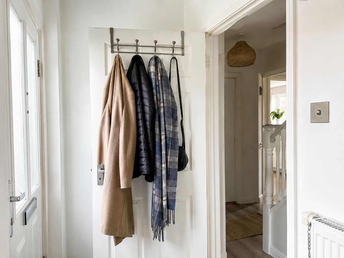 Over-door hook organiser with coats and scarves on hallway door
