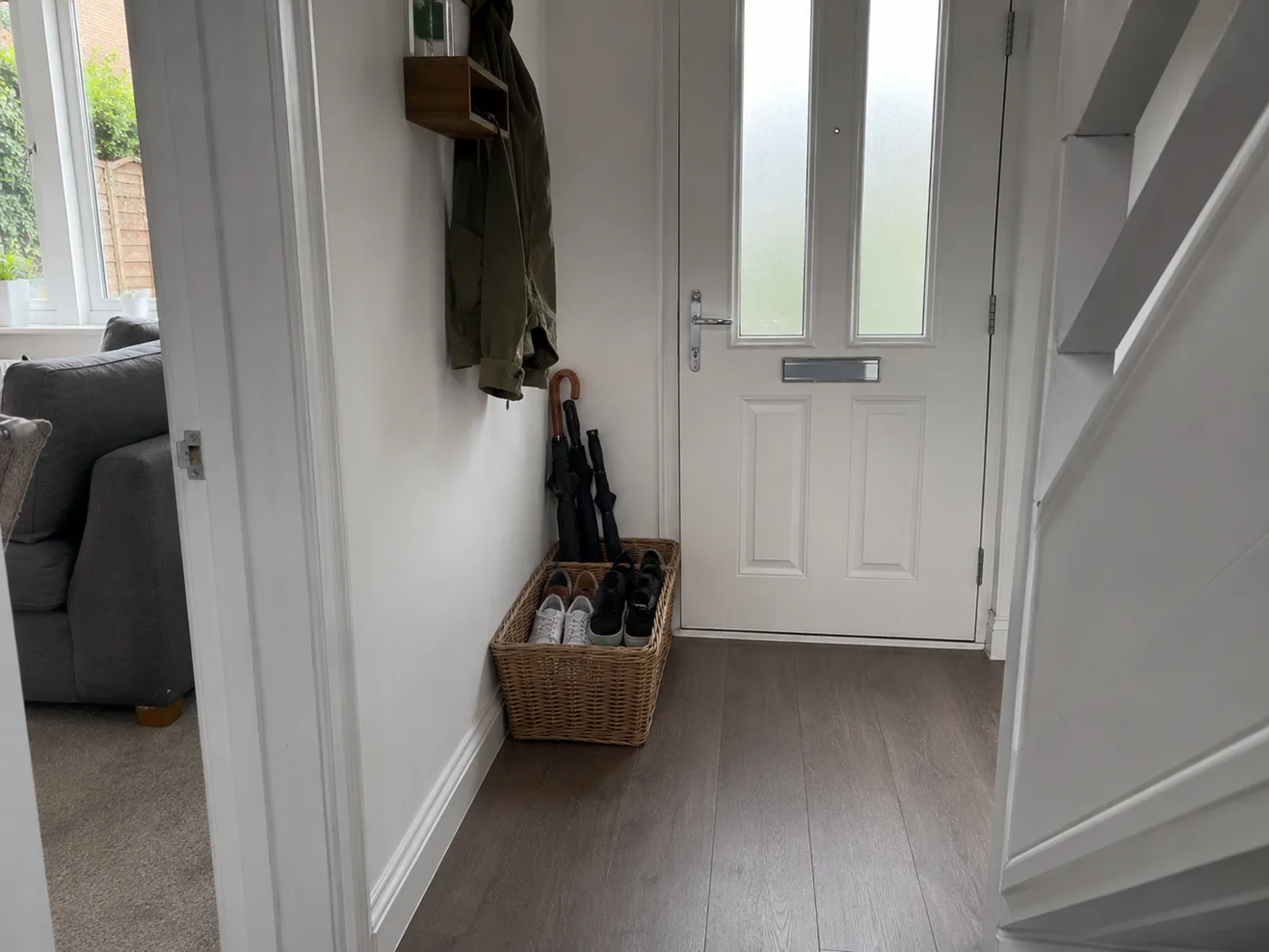 Adhesive hooks on hallway wall holding bags and totes