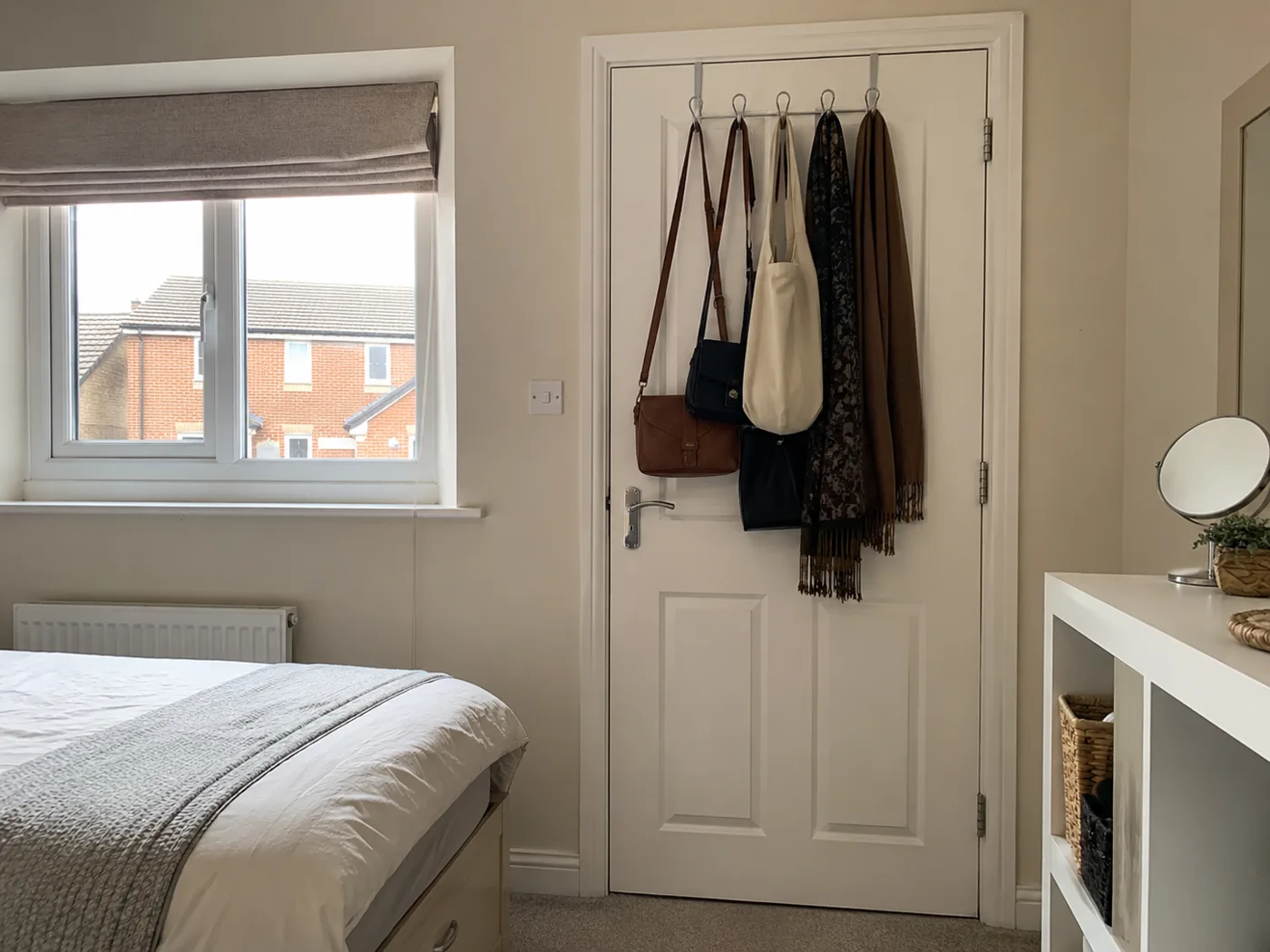Over-door hook organiser with bags and scarves on bedroom door