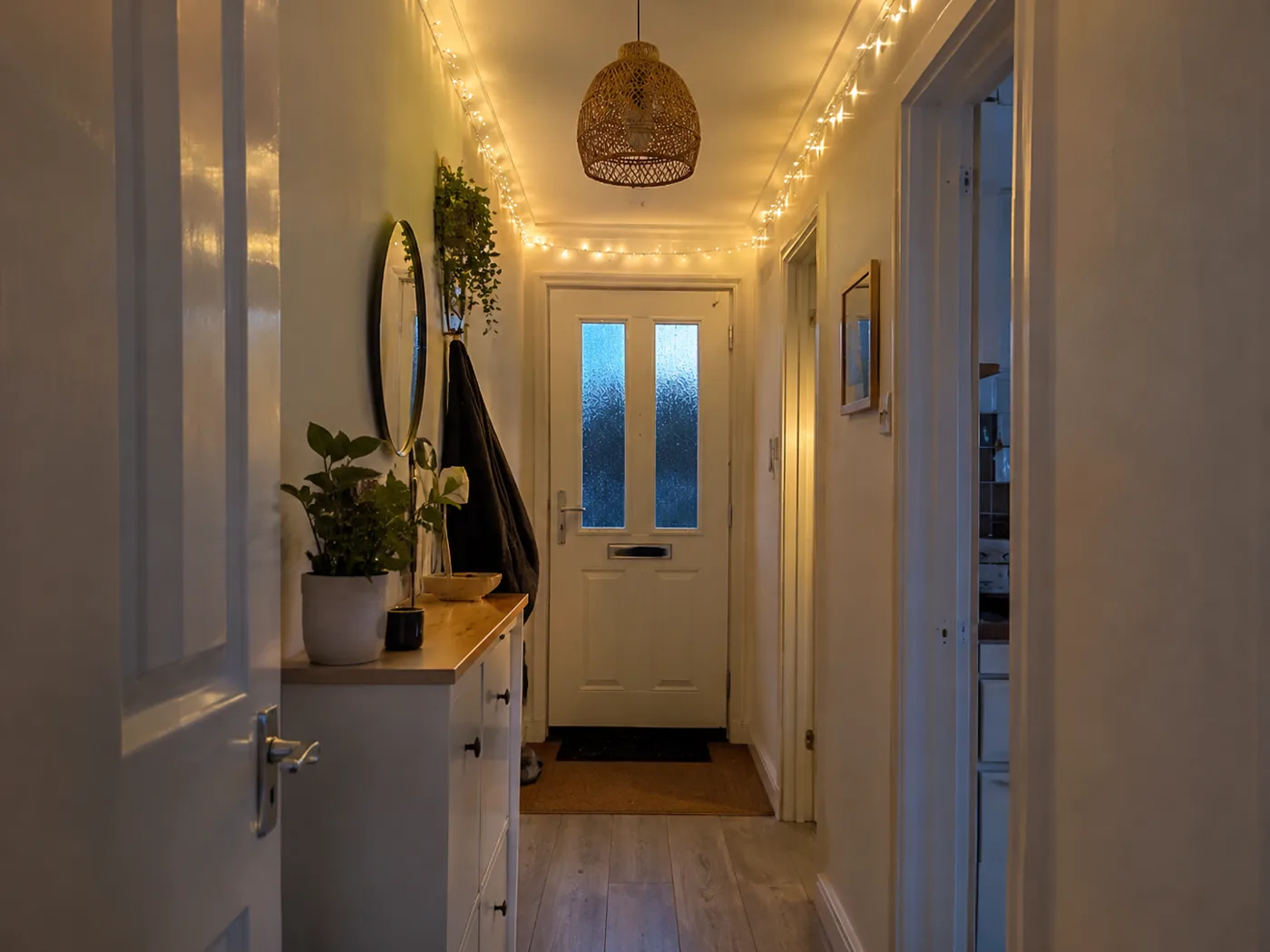 Warm fairy lights along hallway ceiling edge at dusk