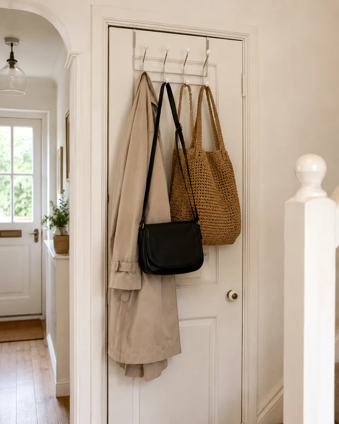 Over-door hook organiser with bags and coats on hallway door