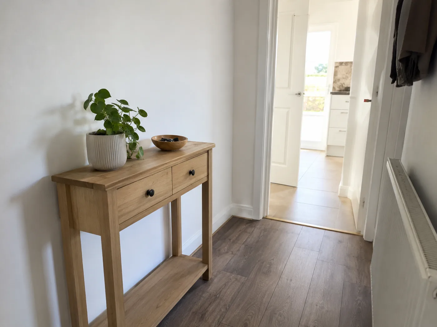 Narrow console table with plant and keys bowl in hallway