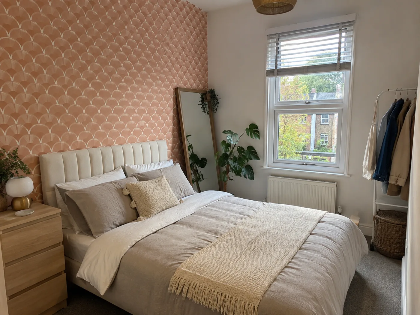 Bedroom with removable terracotta peel-and-stick wallpaper on one wall