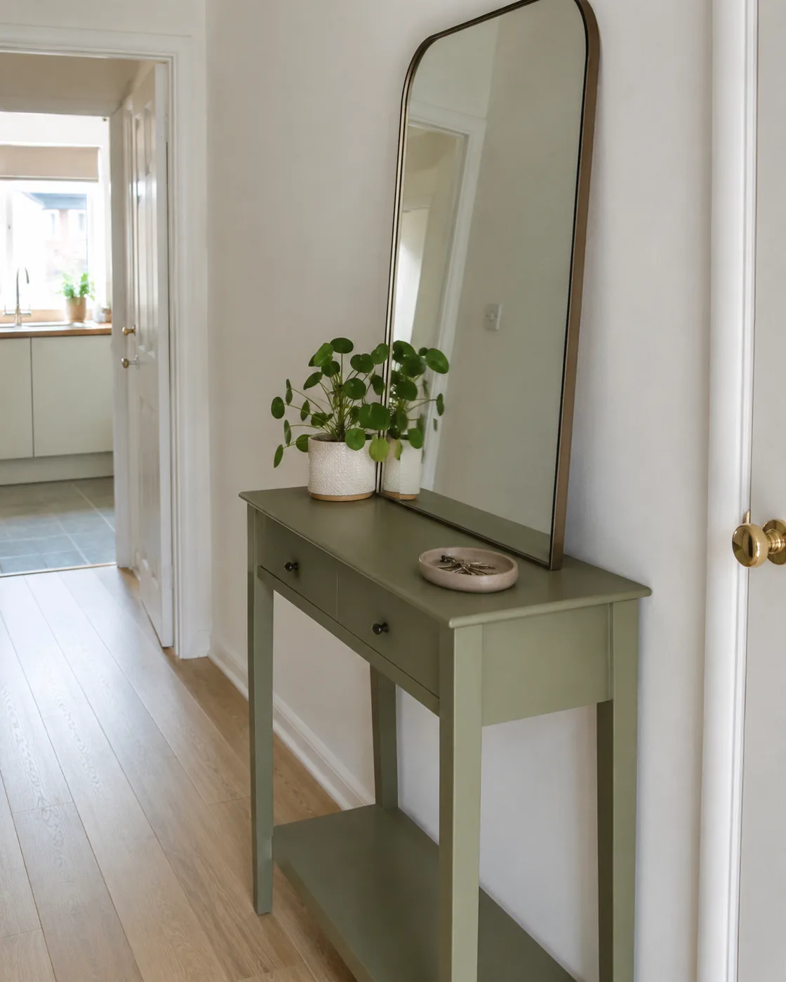 Sage green console table with mirror above in hallway