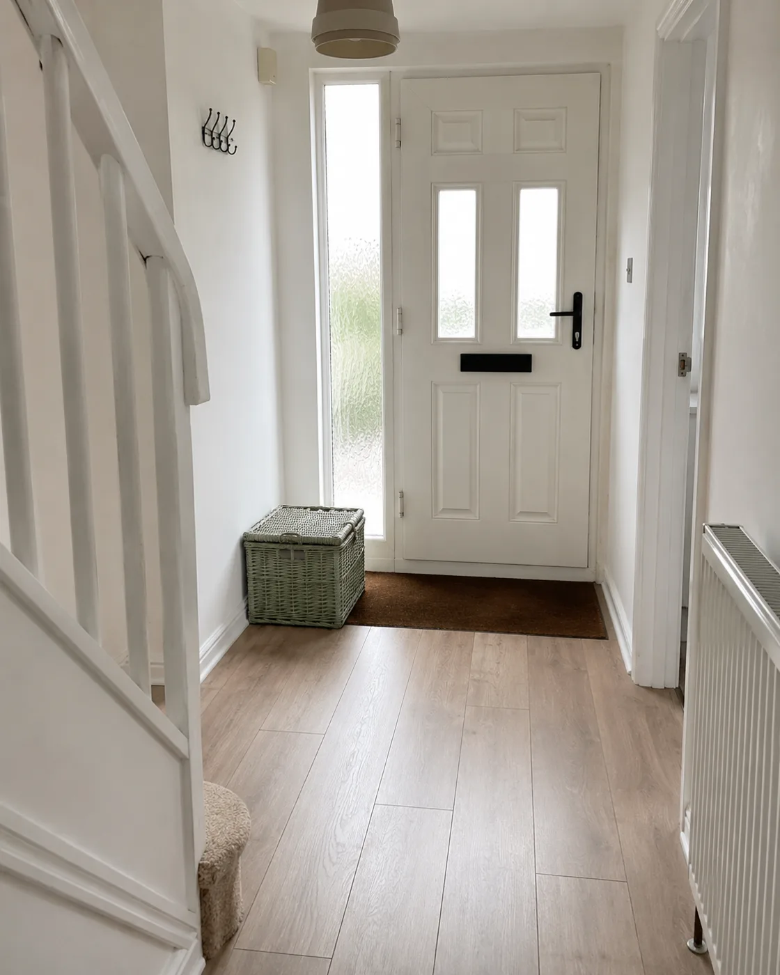 Sage green umbrella stand beside front door in hallway