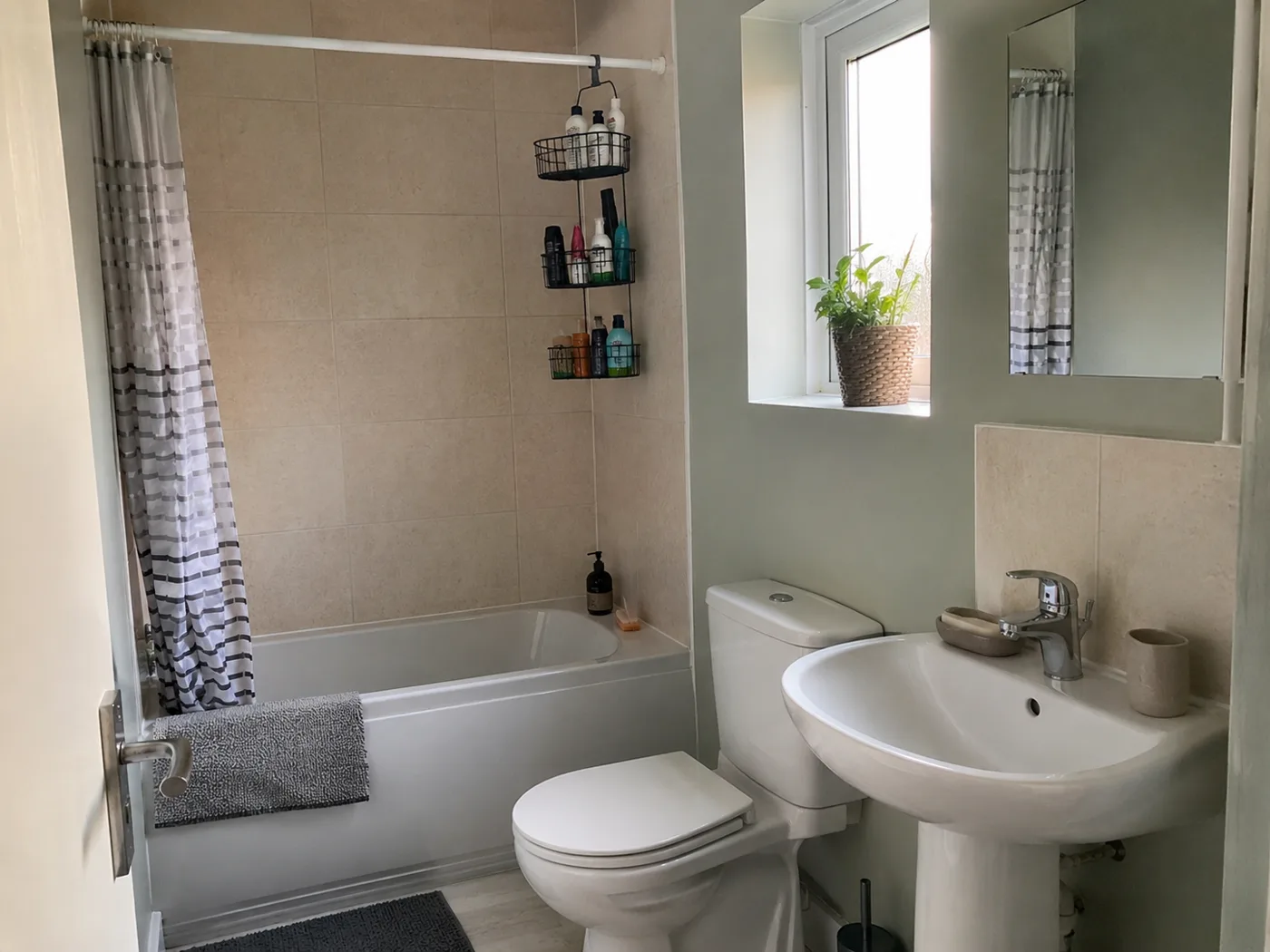 Bathroom with shower curtain and storage caddy on rail